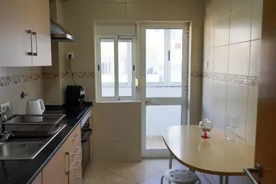 a kitchen with a table and a counter top at Apartamento T3 in Faro
