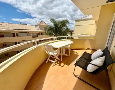 a balcony with a table and chairs on a balcony at Vilamoura-Praia da Falésia T2 in Quarteira