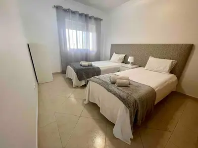 a bedroom with two beds and a window at Vilamoura-Praia da Falésia T2 in Quarteira