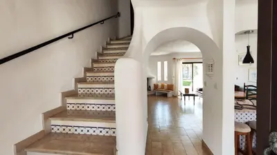 a staircase in a home with a white stair case at Sao Rafael T2 Duplex, Albufeira in Albufeira