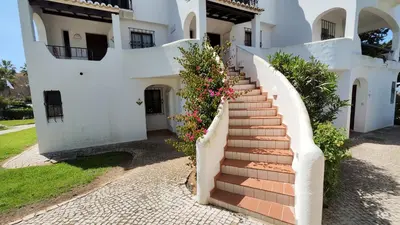 a staircase leading up to a white house with flowers at Sao Rafael T2 Duplex, Albufeira in Albufeira