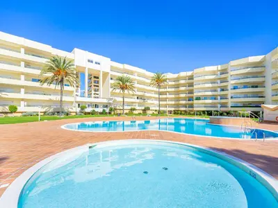 a swimming pool in front of a large apartment building at Luxury Apart wStunning Sea Views, Walk Beach in Albufeira