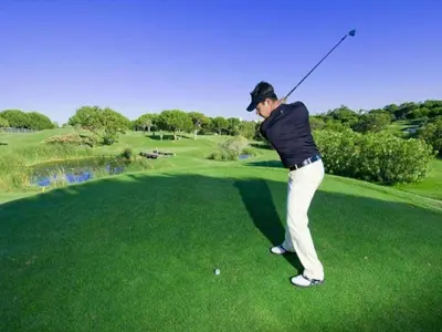 a woman swinging a golf club on a golf course at Luxury Apart wStunning Sea Views, Walk Beach in Albufeira