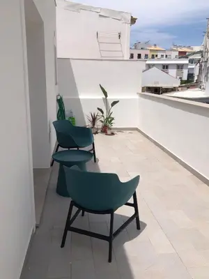 a balcony with two chairs sitting on a roof at A Casa da Elsa in Faro