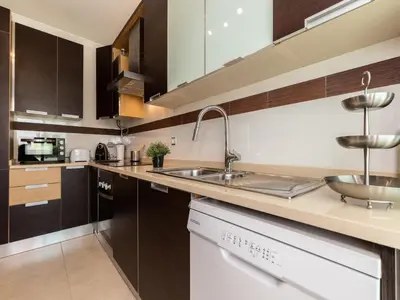 a kitchen with brown cabinets and a sink at Akisol Olhos de Água Lyrical in Albufeira