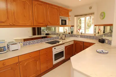 a kitchen with wooden cabinets and a stove top oven at SÃO RAFAEL BEACH VILLAGE 131 - Apartamento T2 Praia de São Rafael - Albufeira in Albufeira