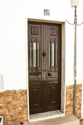 a wooden door on the side of a building at Casa Clementina in Albufeira