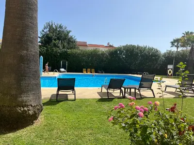 a group of chairs sitting next to a swimming pool at LV Apartment Albufeira in Albufeira