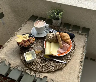 a table with a plate of food and a cup of coffee at LV Apartment Albufeira in Albufeira