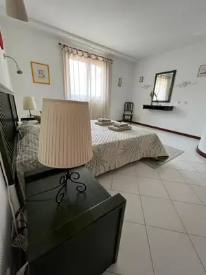 a bedroom with a bed and a table with a lamp at LV Apartment Albufeira in Albufeira