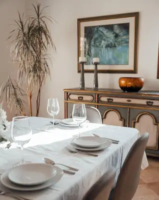 a table with plates and wine glasses on it at Casa das Palmeiras - Villa com piscina, BBQ e ar condicionado in Albufeira