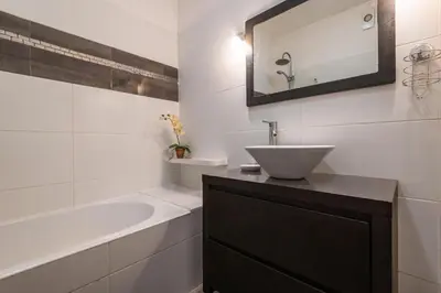 a white bathroom with a sink and a bath tub at Sea View Central Town 2 Bedroom Apartment in Albufeira