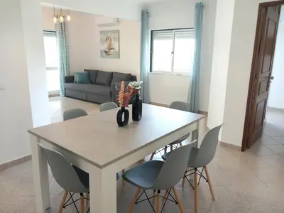 a dining room table and chairs in a living room at Apartamento Jade by Sunnyway in Albufeira