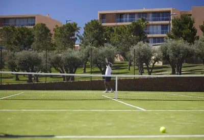 a person is playing tennis on a tennis court at Herdade dos Salgados - 2 Bedroom in Guia