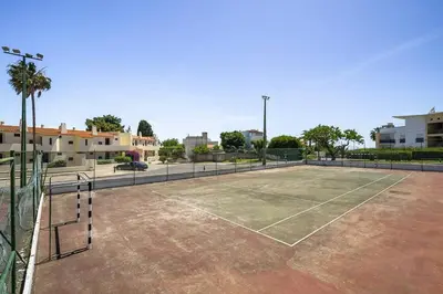 a tennis court with a net on top of it at Garden Paradise, Old Town & Beach in Albufeira