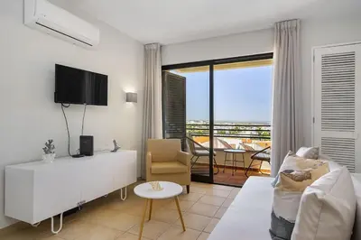 a living room with a couch and a tv and a table at Garden Paradise, Old Town & Beach in Albufeira