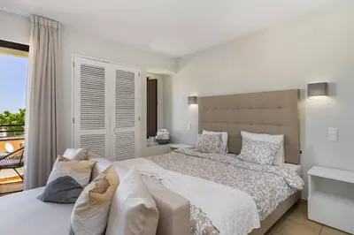 a white bedroom with a large bed and a balcony at Garden Paradise, Old Town & Beach in Albufeira