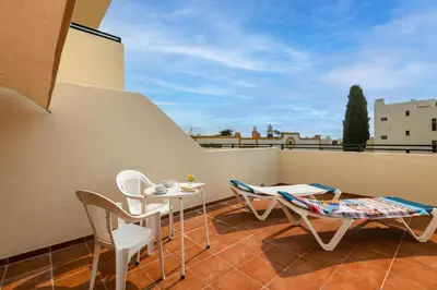 a small kitchen with white cabinets and a refrigerator at Albufeira Jardim Sun Deck Studio in Albufeira
