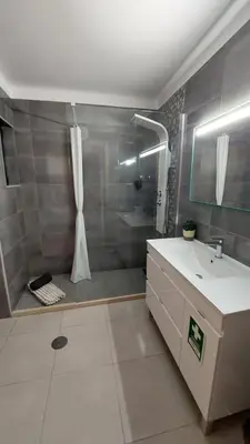a bathroom with a shower and a sink and a tub at Casa Azinheira - Albufeira in Albufeira