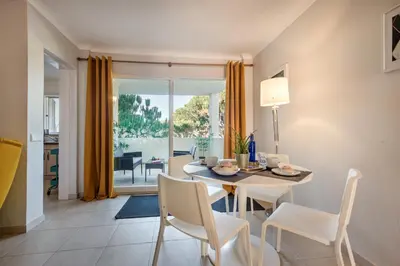 a dining room with a table and chairs with a view of the ocean at Appartement Vale Lobo Mer Golf & Belle Piscine in Vale do Lobo