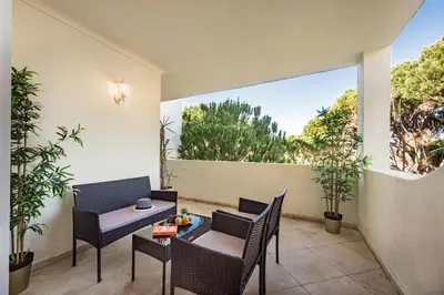 a patio with chairs and a table and a window at Appartement Vale Lobo Mer Golf & Belle Piscine in Vale do Lobo