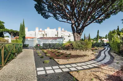 a garden with a tree and a walkway at Appartement Vale Lobo Mer Golf & Belle Piscine in Vale do Lobo