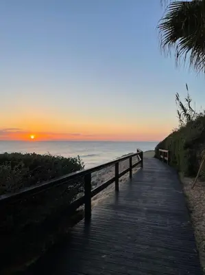 a wooden boardwalk leading to the beach at sunset at Appartement Vale Lobo Mer Golf & Belle Piscine in Vale do Lobo
