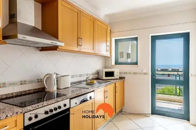 a kitchen with a sink and a microwave and a window at #166 Frat Apartment by Home Holidays in Albufeira