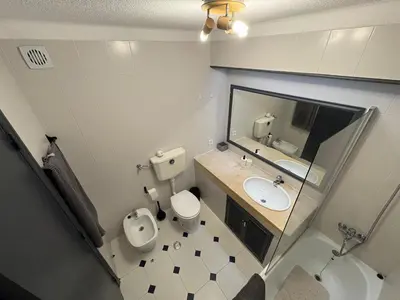 a bathroom with a toilet and a sink and a mirror at Coral By Albufeira Rental in Albufeira