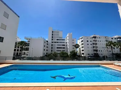 a swimming pool in the middle of a city with buildings at Luxury Modern Beach Apartment in Quarteira