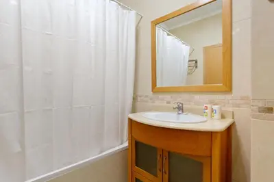 a bathroom with a sink and a shower with a mirror at Encosta da Orada By Albufeira Rental in Albufeira