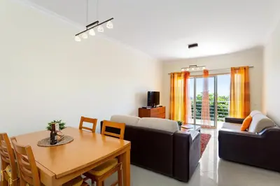 a living room with a table and a couch at Encosta da Orada By Albufeira Rental in Albufeira