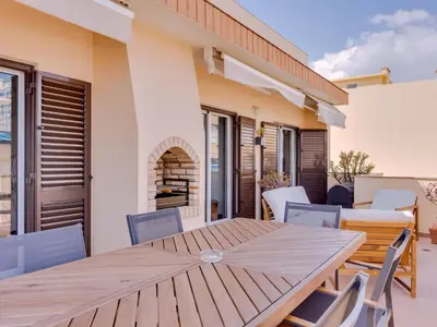 a wooden table and chairs on the patio of a house at AL - Quarteira Terrace Penthouse in Quarteira