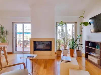 a living room with a fireplace and potted plants at AL - Quarteira Terrace Penthouse in Quarteira