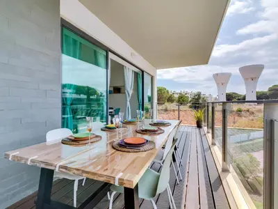 a dining room with a wooden table and chairs at AL - Residence Golf Club Modern Apartment in Vilamoura