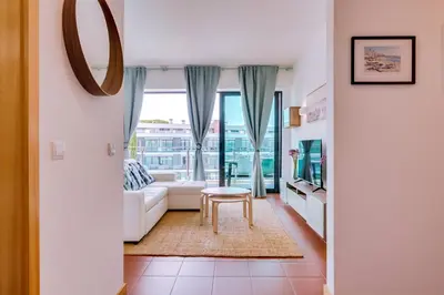a living room with a white couch and a table at AL - Residence Golf Club Modern Apartment in Vilamoura