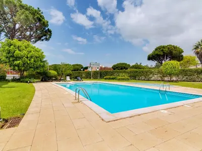 a swimming pool in a yard with trees at AL - Apartamento Village Atlântico in Vilamoura