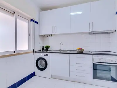 a white kitchen with a washing machine and a sink at AL - Apartamento Village Atlântico in Vilamoura