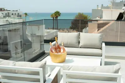 a table with two chairs and a couch on a balcony at Orange Boutique Residence - Casa Diogo in Quarteira