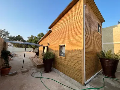 a building with a green hose attached to it at Wood11 - Charming TinyHouse in a Lovely Garden in Santa Bárbara de Nexe