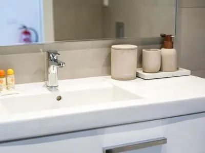a bathroom counter with a sink and a mirror at Green 1 Apartment by Stay ici Algarve Holiday Rental in Albufeira