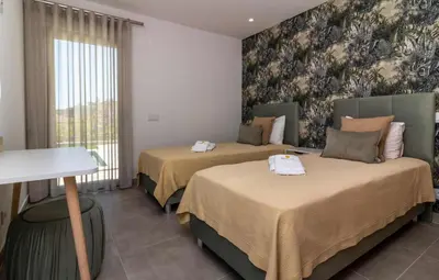 a hotel room with two beds and a window at Villa Orada 25 by Stay ici Algarve Holiday Rental in Albufeira