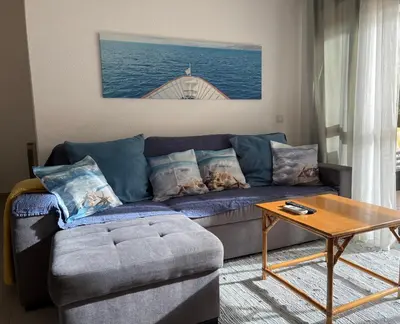 a living room with a blue couch and a table at Happydreams apartment in Albufeira in Albufeira