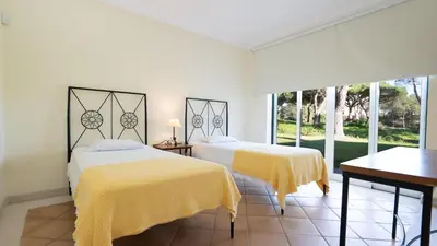 two beds in a white room with yellow sheets at Casa Atlantico in Quinta do Lago