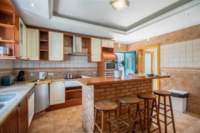a kitchen with a counter and stools in it at Villa Iris in Albufeira