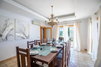 a dining room with a long table and chairs at Villa Iris in Albufeira