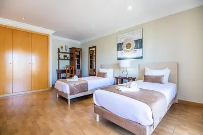 a bedroom with two beds and a wooden floor at Villa Iris in Albufeira