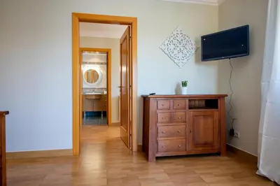 a hallway with a television and a wooden dresser at Villa Iris in Albufeira