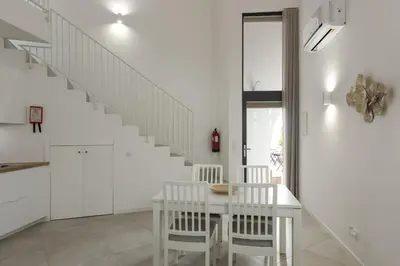 a white dining room with a white table and white stairs at Madalena Village 3 - City centre by HD PROPERTIES in Faro