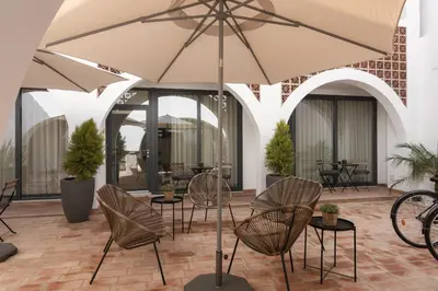 a patio with chairs and an umbrella at Madalena Village 3 - City centre by HD PROPERTIES in Faro